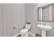 Powder bathroom featuring patterned wallpaper, pedestal sink and decorative framed mirror at 5172 S Seton Ave, Gilbert, AZ 85298