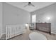 Bedroom room with gray crib, soft chair, dresser, neutral carpet and shutters at 5172 S Seton Ave, Gilbert, AZ 85298