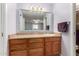 Bathroom vanity with wood cabinets and a white sink below a large mirror at 6409 E Duncan St, Mesa, AZ 85205