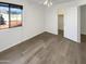 Bright bedroom features a large window, wood-look flooring, and closet for storage at 7009 W Lincoln St, Peoria, AZ 85345