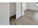 Bright bedroom featuring light wood-look floors and a walk-in closet with a white door at 7009 W Lincoln St, Peoria, AZ 85345