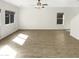 Spacious, well-lit living area with modern ceiling fan, neutral color palette, and wood-look flooring at 7009 W Lincoln St, Peoria, AZ 85345