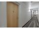 Well-lit hallway leading to various rooms, featuring neutral walls and patterned carpet at 7147 E Rancho Vista Dr # 4007, Scottsdale, AZ 85251