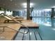 An indoor pool area with lounge chairs, large windows, and tile flooring at 7157 E Rancho Vista Dr # 6011, Scottsdale, AZ 85251