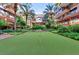 Community putting green with red flags and lush landscaping with upscale condo building in background at 7157 E Rancho Vista Dr # 6011, Scottsdale, AZ 85251