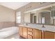 Bathroom with double vanity, soaking tub, and tiled shower at 7830 S 26Th St, Phoenix, AZ 85042