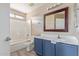 Bathroom with a white shower-tub combo, blue vanity, and wood-style flooring at 7830 S 26Th St, Phoenix, AZ 85042