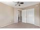 Bedroom with sliding door closet, neutral carpet and access to an adjacent bathroom at 7830 S 26Th St, Phoenix, AZ 85042