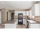 Open-concept kitchen featuring white cabinets, a center island, and modern appliances at 7830 S 26Th St, Phoenix, AZ 85042