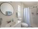 Bright bathroom includes a vanity, toilet, mirror and shower/tub combo at 9709 E Empress Ave, Mesa, AZ 85208