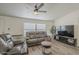 Cozy living room featuring modern ceiling fan, vinyl floors and comfortable reclining furniture at 9709 E Empress Ave, Mesa, AZ 85208