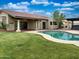 Backyard featuring a refreshing swimming pool, covered patio, and well-maintained lawn at 9740 E Gold Dust Ave, Scottsdale, AZ 85258