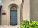 Front door with a transom window and a stone entryway, enhanced by lush landscaping at 9740 E Gold Dust Ave, Scottsdale, AZ 85258