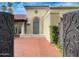 View through open iron gates to the front door, featuring an arched entry and brick pavers at 9740 E Gold Dust Ave, Scottsdale, AZ 85258