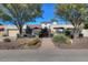 Charming single-story home featuring an ornate front gate and landscaped front yard with desert plants and trees at 9740 E Gold Dust Ave, Scottsdale, AZ 85258