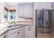 Kitchen boasts stainless steel refrigerator, granite counters, tile backsplash, and soft-close cabinets at 9740 E Gold Dust Ave, Scottsdale, AZ 85258
