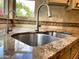 Close-up of a kitchen sink with granite countertops, dual basin sink and a window view at 9740 E Gold Dust Ave, Scottsdale, AZ 85258