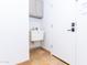 Functional laundry room features a utility sink, storage cabinet, white walls, and tile floors at 9740 E Gold Dust Ave, Scottsdale, AZ 85258