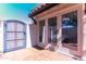 Private brick patio has double glass doors leading indoors, a gate, and neutral-toned stucco walls at 9740 E Gold Dust Ave, Scottsdale, AZ 85258