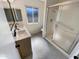 Bright bathroom with a double sink vanity, tiled floors, and glass enclosed shower at 9814 N Balboa Dr, Sun City, AZ 85351