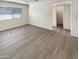Well-lit room showcasing attractive wood floors, a ceiling fan, and convenient access to other areas of the home at 9814 N Balboa Dr, Sun City, AZ 85351