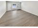 Spacious room with light gray wood flooring, a large window, and a neutral color scheme, ready for customization at 9814 N Balboa Dr, Sun City, AZ 85351