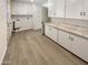 Bright laundry room with ample storage, white cabinets and marble countertops at 9814 N Balboa Dr, Sun City, AZ 85351