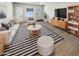 Bright living room with modern furnishings, stylish striped rug, and ample natural light, perfect for relaxation and entertainment at 9814 N Balboa Dr, Sun City, AZ 85351