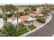 Aerial view of a white stucco home with a tile roof, green lawn, mature trees, and a brick driveway at 10435 N 98Th St, Scottsdale, AZ 85258