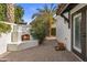 Backyard featuring outdoor fireplace, brick flooring, lush landscaping, and access to the home at 10435 N 98Th St, Scottsdale, AZ 85258