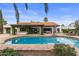 Backyard with large swimming pool, patio, pergola, green vegetation, and lounge furniture at 10435 N 98Th St, Scottsdale, AZ 85258