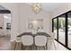 Dining room features modern chandelier, backyard view and access, and neutral color palette at 10435 N 98Th St, Scottsdale, AZ 85258