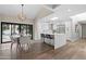Modern kitchen and dining area with stainless steel appliances, white cabinetry, island, and hardwood floors at 10435 N 98Th St, Scottsdale, AZ 85258