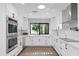 Bright kitchen featuring white cabinets, white countertops, modern appliances, and hardwood floors at 10435 N 98Th St, Scottsdale, AZ 85258