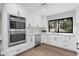 Bright kitchen featuring white cabinets, white countertops, stainless steel appliances, and hardwood floors at 10435 N 98Th St, Scottsdale, AZ 85258