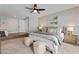 Spacious bedroom with neutral colors, ceiling fan, artwork, and cozy seating area at 10435 N 98Th St, Scottsdale, AZ 85258