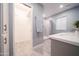Bright bathroom featuring modern vanity, tiled shower, wood-look tile and walk-in closet at 10523 W Roundelay Cir, Sun City, AZ 85351