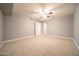 Spacious bedroom featuring neutral carpet, ceiling fan and two entry doors at 10523 W Roundelay Cir, Sun City, AZ 85351