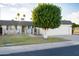 Charming single-level home featuring a two-car garage, mature trees, and manicured landscaping at 10523 W Roundelay Cir, Sun City, AZ 85351