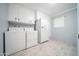 Laundry room features appliances, plenty of storage in white cabinets and a window at 10523 W Roundelay Cir, Sun City, AZ 85351