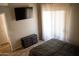 Modern bedroom with a wall-mounted TV and sleek black dresser with soft, neutral colors and natural light at 11666 N 28Th Dr # 298, Phoenix, AZ 85029