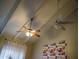 Bedroom view of vaulted ceiling with two ceiling fans and a Minnesota Vikings tapestry at 11666 N 28Th Dr # 298, Phoenix, AZ 85029