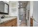 Well-lit bathroom featuring a granite-topped vanity, framed mirror, and glass-enclosed shower at 11772 E Clinton St, Scottsdale, AZ 85259