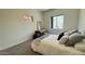 Bright bedroom features a comfortable bed, a small desk and a large, sunlit window at 11772 E Clinton St, Scottsdale, AZ 85259