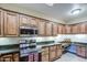 Functional kitchen with stainless steel appliances, granite countertops, and ample wood cabinet space at 11772 E Clinton St, Scottsdale, AZ 85259