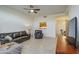 Cozy living room featuring leather sofa, ceiling fan, and a view into the dining area at 11772 E Clinton St, Scottsdale, AZ 85259