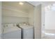 Laundry room with a washer, dryer, and open shelving for storage at 11840 N 40Th Way, Phoenix, AZ 85028