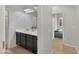 This bathroom features double sinks, dark cabinetry, and wood-look floors at 12227 W Prickly Pear Trl, Peoria, AZ 85383
