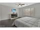 Cozy bedroom with hardwood floors, ceiling fan, dresser and bright window at 12227 W Prickly Pear Trl, Peoria, AZ 85383