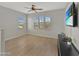 This bonus room features wood-look floors, three windows with blinds, and a ceiling fan at 12227 W Prickly Pear Trl, Peoria, AZ 85383